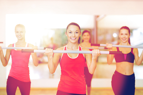 fitness, sport, training, gym and lifestyle concept - group of smiling people working out with barbells in the gym