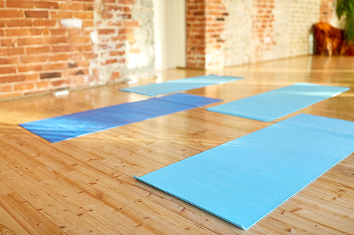 fitness, sport and healthy lifestyle concept - yoga mats on floor at gym or studio