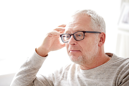 old age, problem and people concept - close up of senior man in glasses thinking