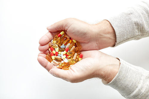 old age, medicine, drugs, healthcare and people concept - close up of senior man hands holding pills