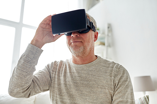 technology, augmented reality, gaming, entertainment and people concept - senior man with virtual headset or 3d glasses playing videogame at home