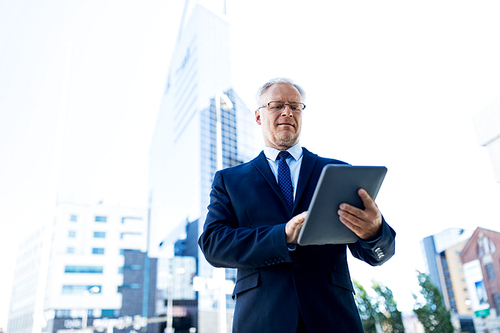 business, technology and people concept - senior businessman with tablet pc computer on city street