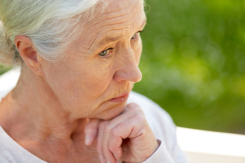 old age, retirement and people concept - sad senior woman in glasses sitting on bench at summer park