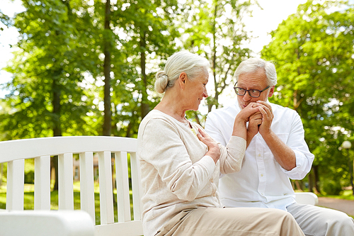 old age, relationship and people concept - happy senior couple hugging in city park