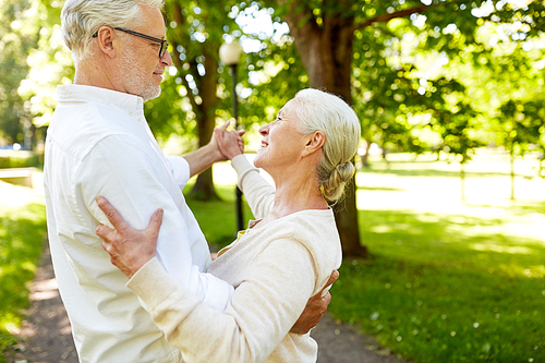 old age, relationship and people concept - happy senior couple dancing waltz at summer city park