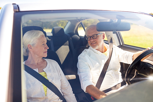 road trip, travel and old people concept - happy senior couple driving in car