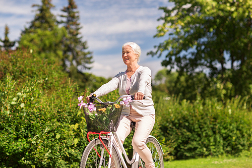 active old age, people and lifestyle concept - happy senior woman riding fixie bicycle at summer park