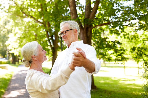 old age, relationship and people concept - happy senior couple dancing waltz at summer city park