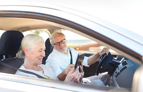 road trip, travel and old people concept - happy senior couple with tablet pc computer driving in car