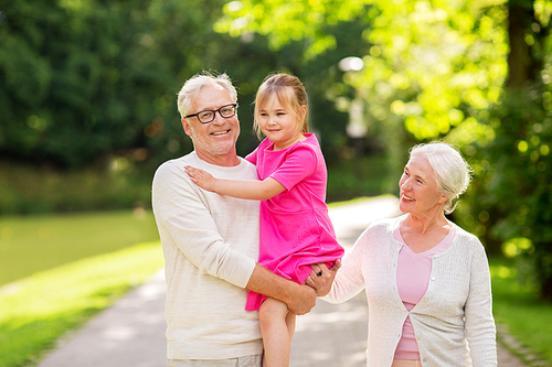 family, generation and people concept - happy smiling grandmother, grandfather and little granddaughter at park