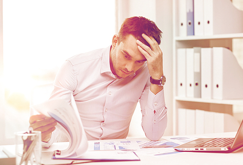 business, people, deadline and technology concept - stressed businessman with laptop computer and papers at office