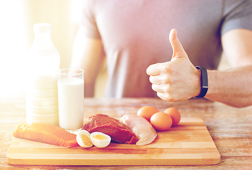 sport, fitness, healthy lifestyle, diet and people concept - close up of man with food rich in protein showing thumbs up