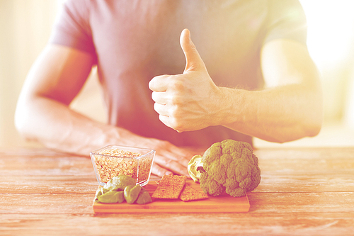 healthy eating, diet, gesture and people concept - close up of male hands showing thumbs up with food rich in fiber