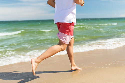 fitness, sport, people and healthy lifestyle concept - happy young man running along summer beach