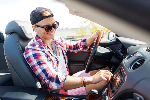 summer holidays, travel, road trip and people concept - happy young man driving convertible car