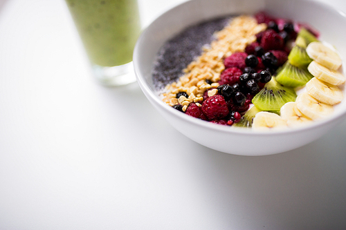 healthy eating, food and diet concept - glass with juice or smoothie and bowl of yogurt with fruits and seeds