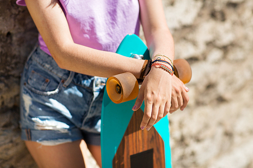 lifestyle, leisure and people concept - close up of teenage girl or young woman with longboard