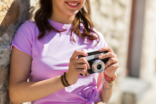 lifestyle, photography and people concept - close up of smiling teenage girl or young woman with vintage camera outdoors