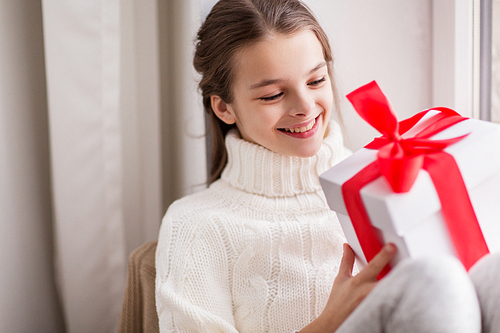 childhood, birthday, holidays and people concept - happy beautiful girl with christmas gift box at home