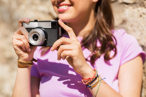 lifestyle, photography and people concept - close up of smiling teenage girl or young woman with vintage camera outdoors