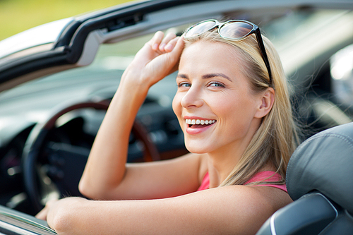 travel, road trip and people concept - happy young woman in convertible car