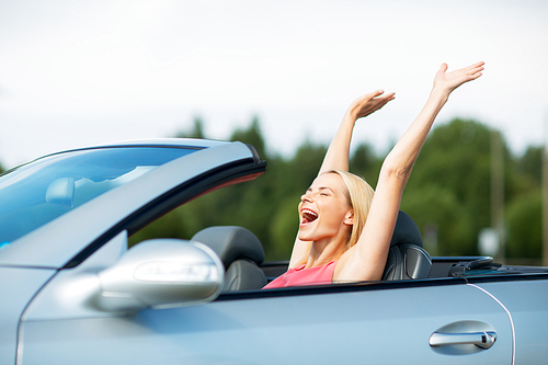 travel, summer holidays, road trip and people concept - happy young woman in convertible car enjoying sun