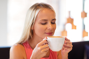 people and leisure concept - close up of happy woman drinking coffee at restaurant