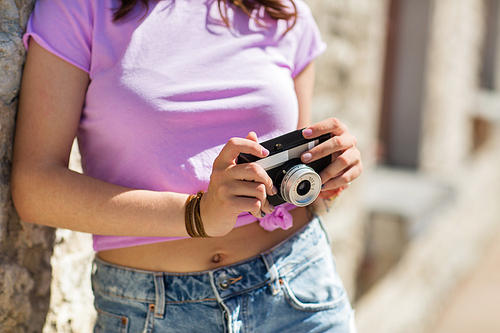 lifestyle, photography and people concept - close up of teenage girl or young woman with vintage camera outdoors