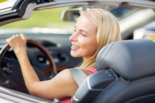 travel, road trip and people concept - happy young woman driving convertible car