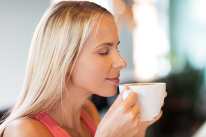 people and leisure concept - close up of happy woman drinking coffee at restaurant