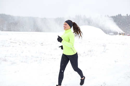 fitness, sport and healthy lifestyle concept - happy smiling woman running outdoors in winter