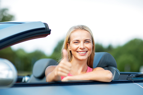 travel, road trip and people concept - happy young woman showing thumbs up in convertible car