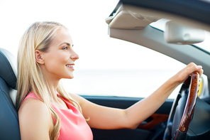travel, road trip and people concept - happy young woman driving convertible car