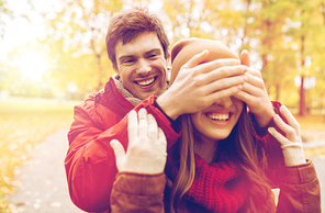 love, relationships, season and people concept - happy young couple having fun in autumn park