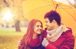 love, relationship, season, family and people concept - happy couple with umbrella walking in autumn park