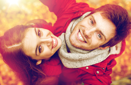 love, technology, relationship, family and people concept - close up of happy smiling young couple taking selfie in autumn park