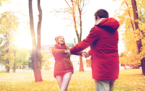 love, relationships, season and people concept - happy young couple having fun in autumn park