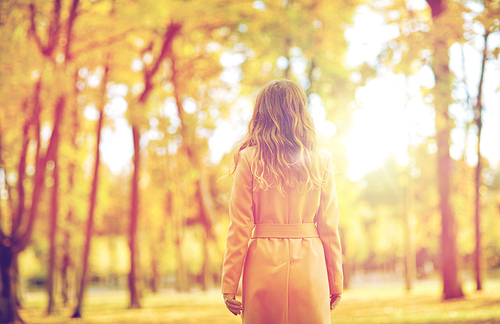 season and people concept - beautiful young woman walking in autumn park