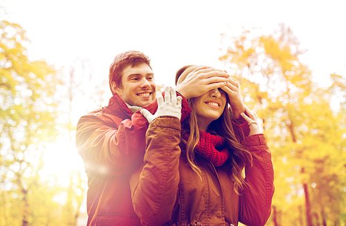 love, relationships, season and people concept - happy young couple having fun in autumn park