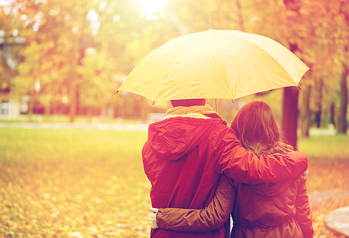 love, relationship, season, family and people concept - happy couple with umbrella walking in autumn park