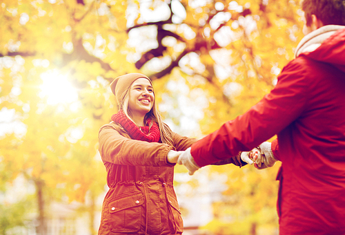 love, relationships, season and people concept - happy young couple having fun in autumn park