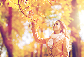 season and people concept - beautiful happy young woman walking in autumn park