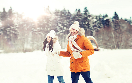 people, season, love and leisure concept - happy couple running over winter background