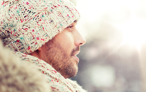 people, season and leisure concept - face of happy man outdoors in winter