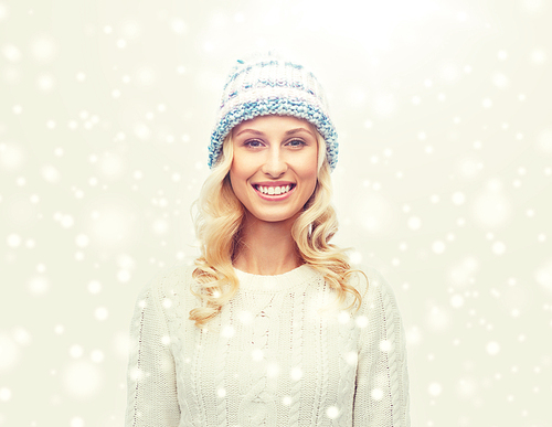 winter, fashion, christmas and people concept - smiling young woman in winter hat, sweater and gloves