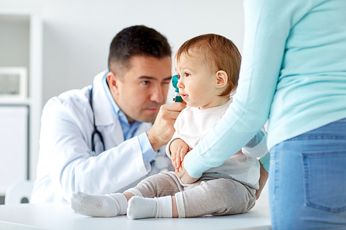 medicine, healthcare, pediatry and people concept - otolaryngologist or doctor checking baby ear with otoscope at clinic