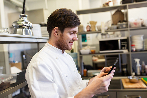 cooking, profession and people concept - happy male chef cook with tablet pc computer at restaurant kitchen