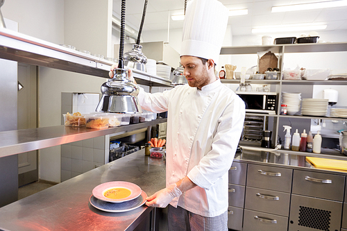 food cooking, profession and people concept - happy male chef cook with cloche and soup at restaurant kitchen