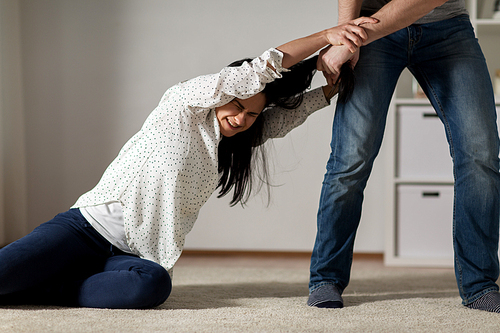 domestic violence, abuse and people concept - couple having fight and man dragging helpless woman by hair at home