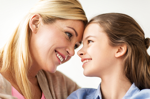 people and family concept - happy smiling girl with mother at home
